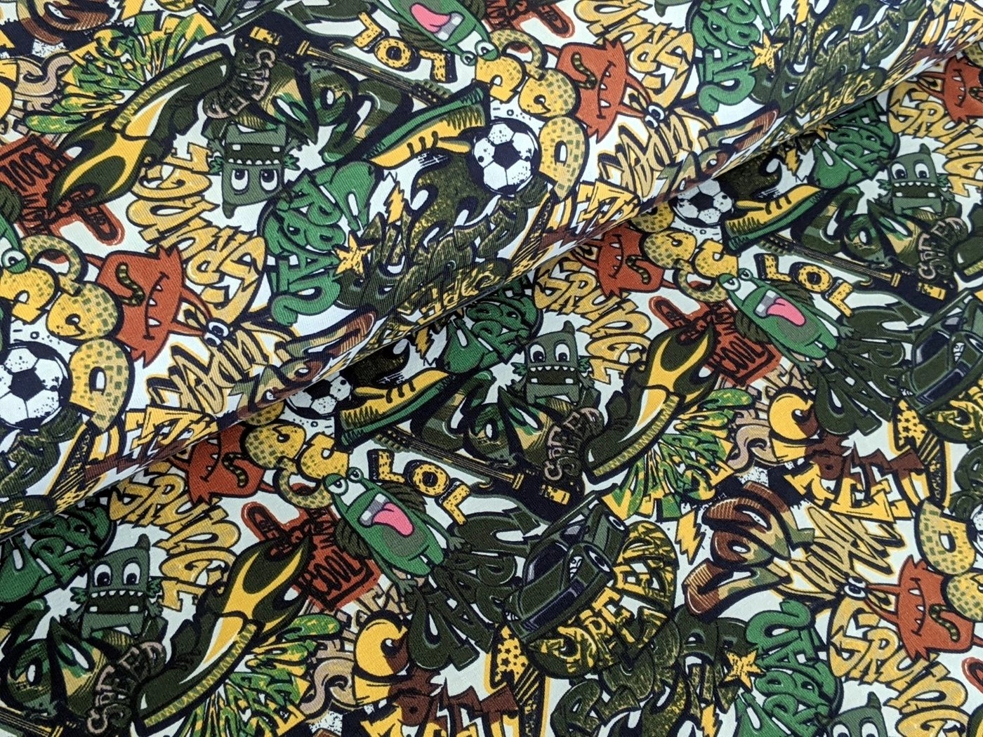 Corileo Stoff »Baumwolljersey Comic Graffiti Kids Fussball Grün Stoff Meterware Jersey«